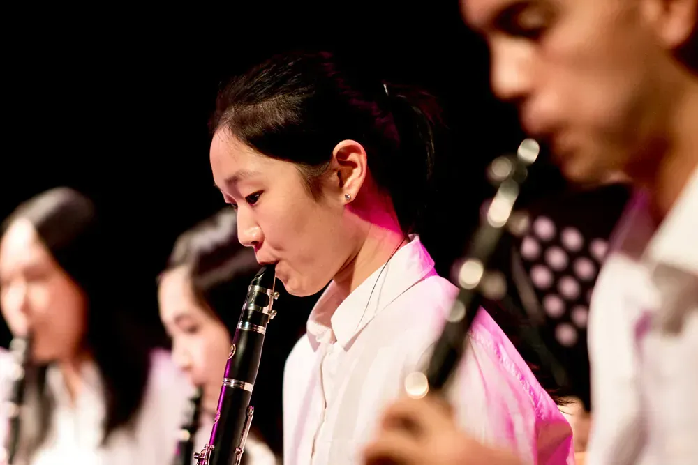 A group of young people are playing clarinets in a band.