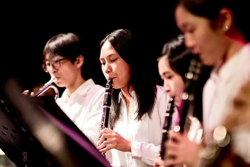 A group of people are playing clarinets in an orchestra.