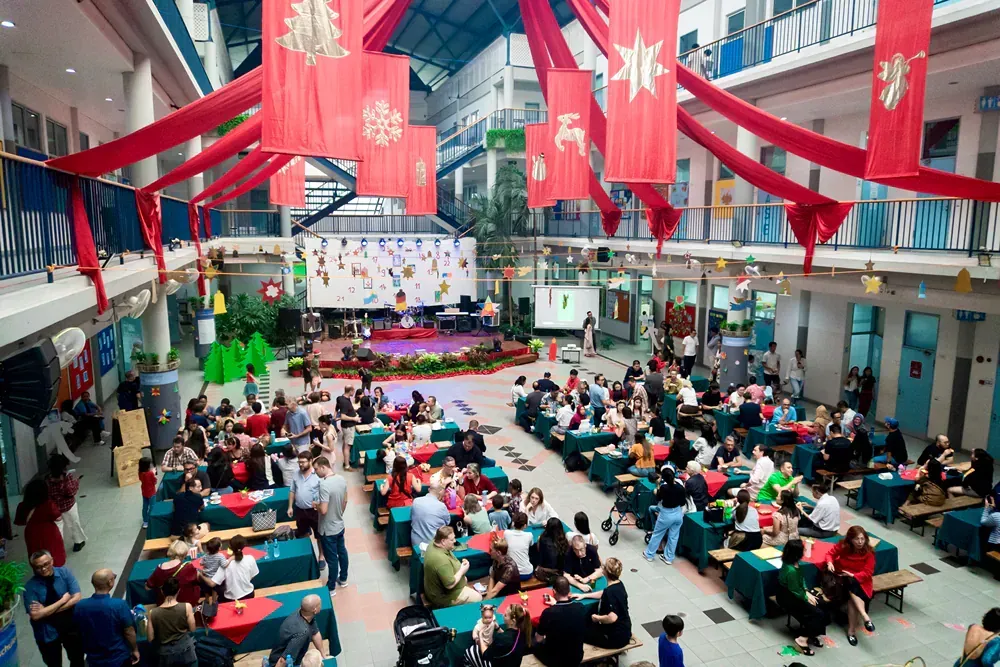 A large group of people are sitting at tables in a large room.