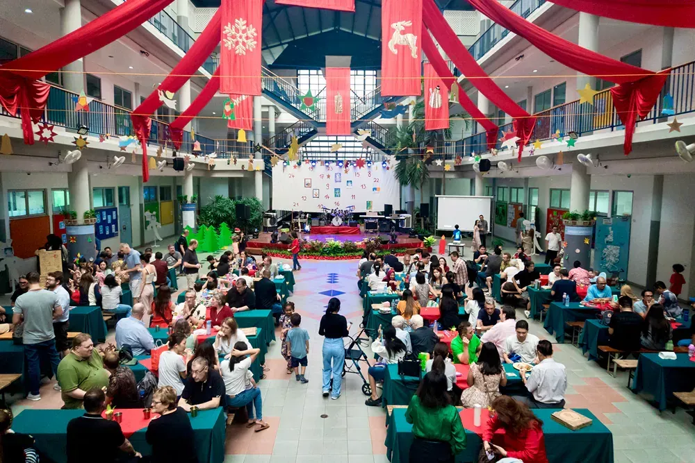 A large group of people are sitting at tables in a large room.