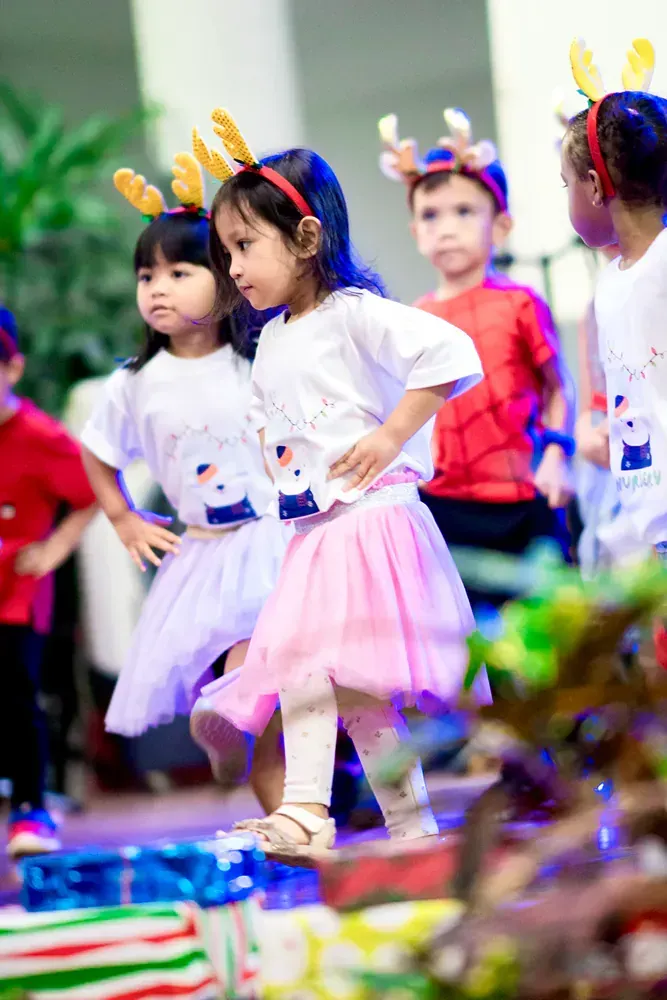 A group of children are dancing together at a christmas party.