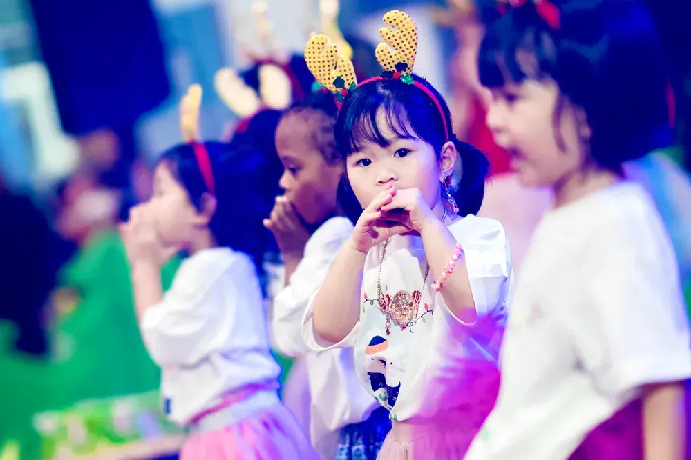 A group of little girls are standing next to each other in a room.