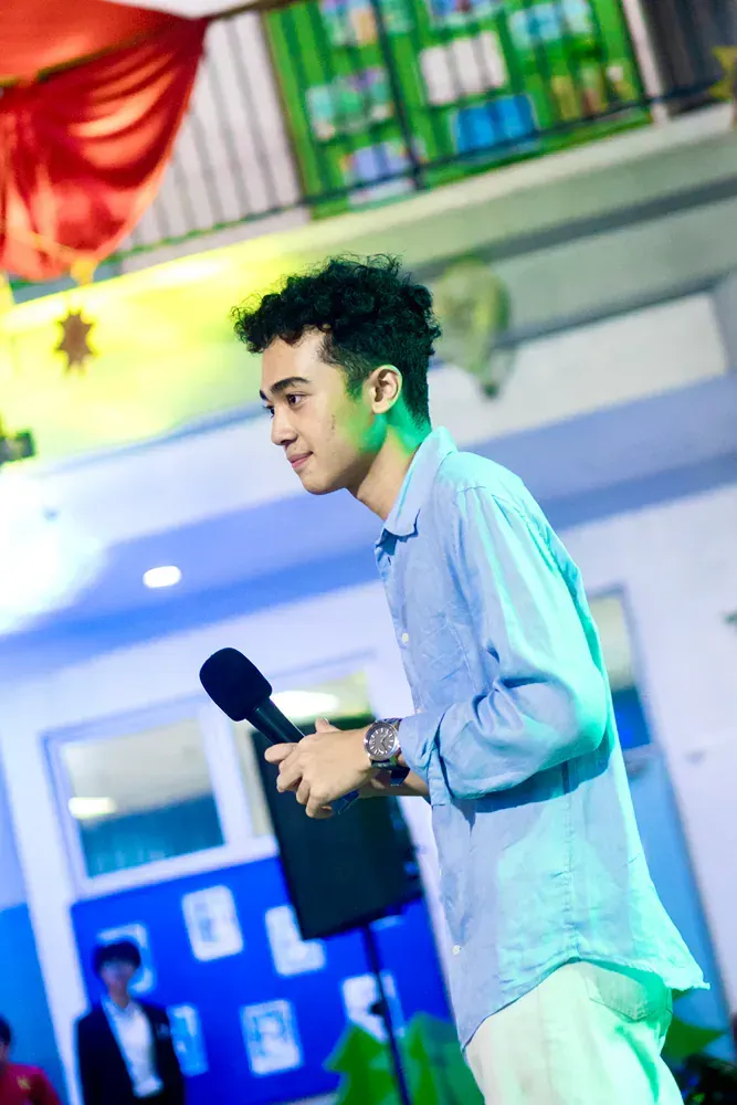 A young man is standing in front of a microphone.