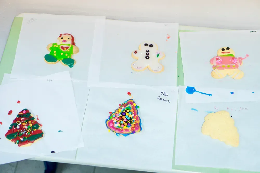 A table topped with drawings of gingerbread men and christmas trees.
