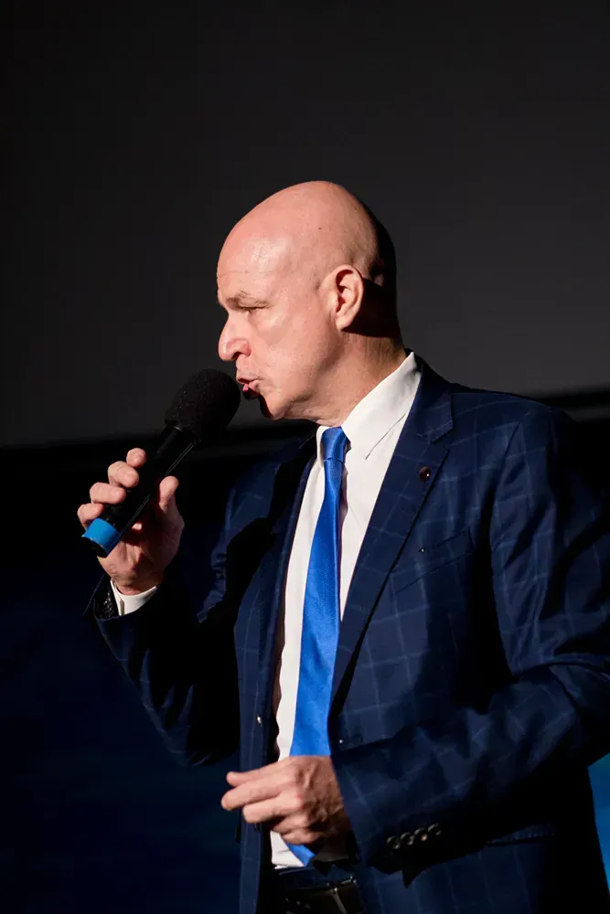 A man in a suit and tie is singing into a microphone.