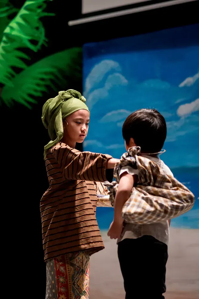 A boy and a girl are standing next to each other on a stage.