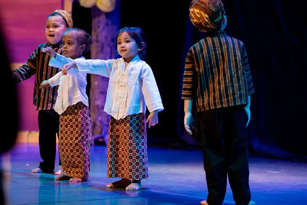 A group of young children are dancing on a stage.