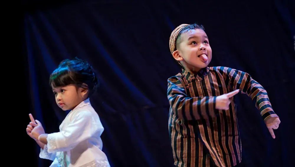 A boy and a girl are dancing on a stage.