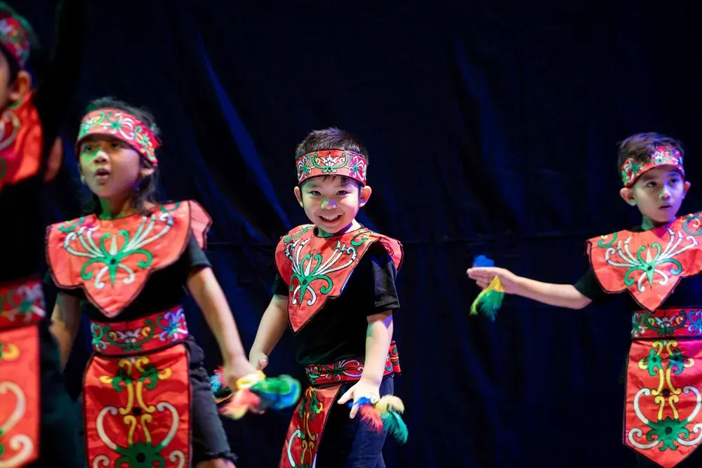 A group of young children are dancing on a stage.