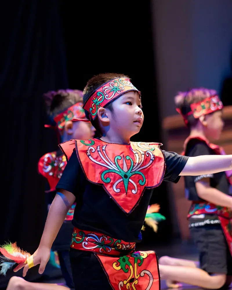 A group of young children are performing a dance on a stage.