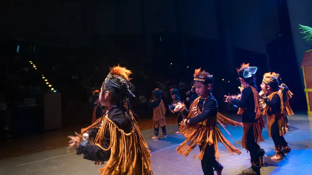 A group of children are dancing on a stage.