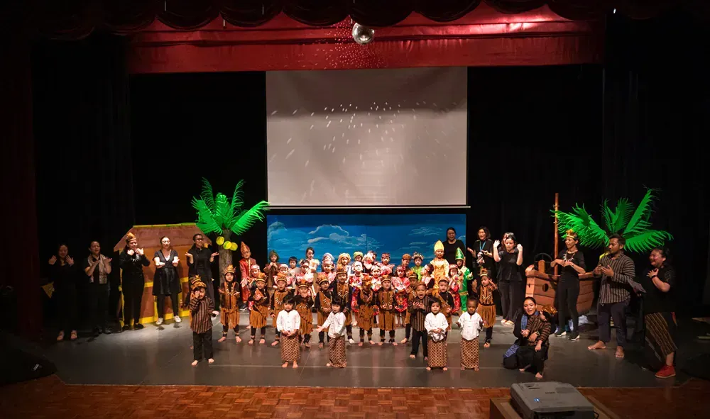 A group of people are standing on a stage in front of a large screen.