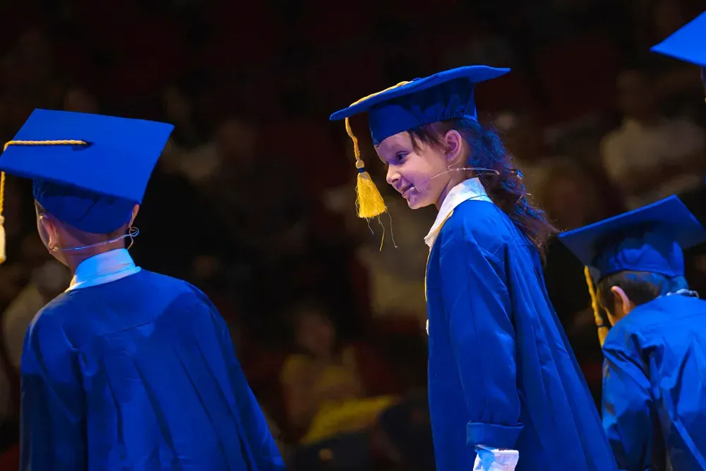 A group of children are wearing graduation caps and gowns.