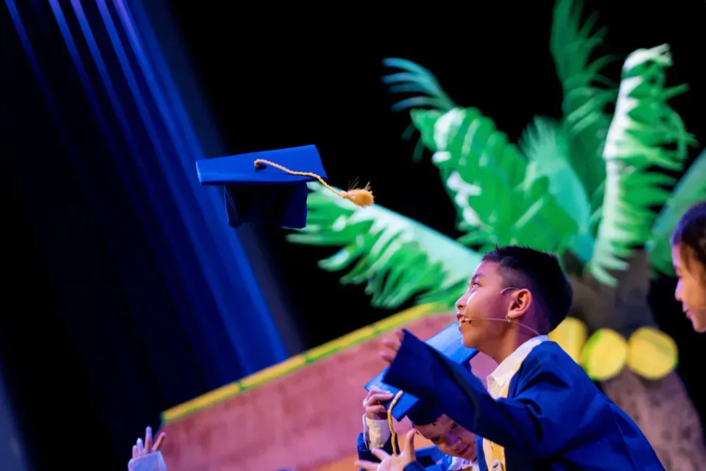 A boy is throwing a graduation cap in the air.