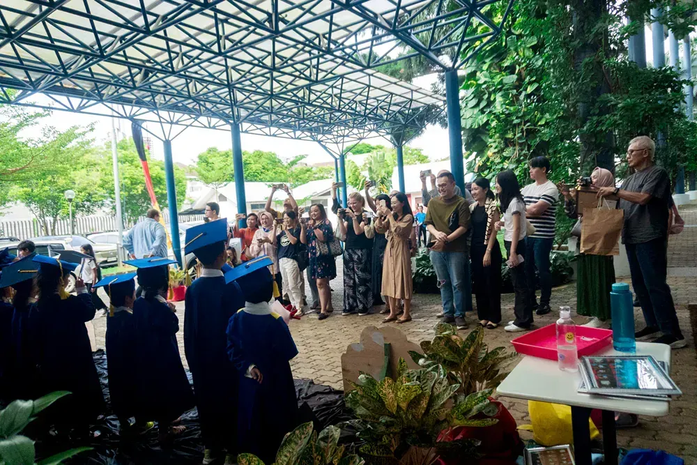A group of people in graduation caps and gowns are standing under a canopy.
