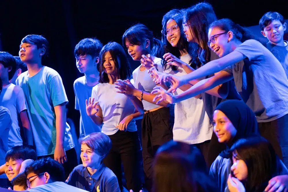 A group of children are standing next to each other on a stage.