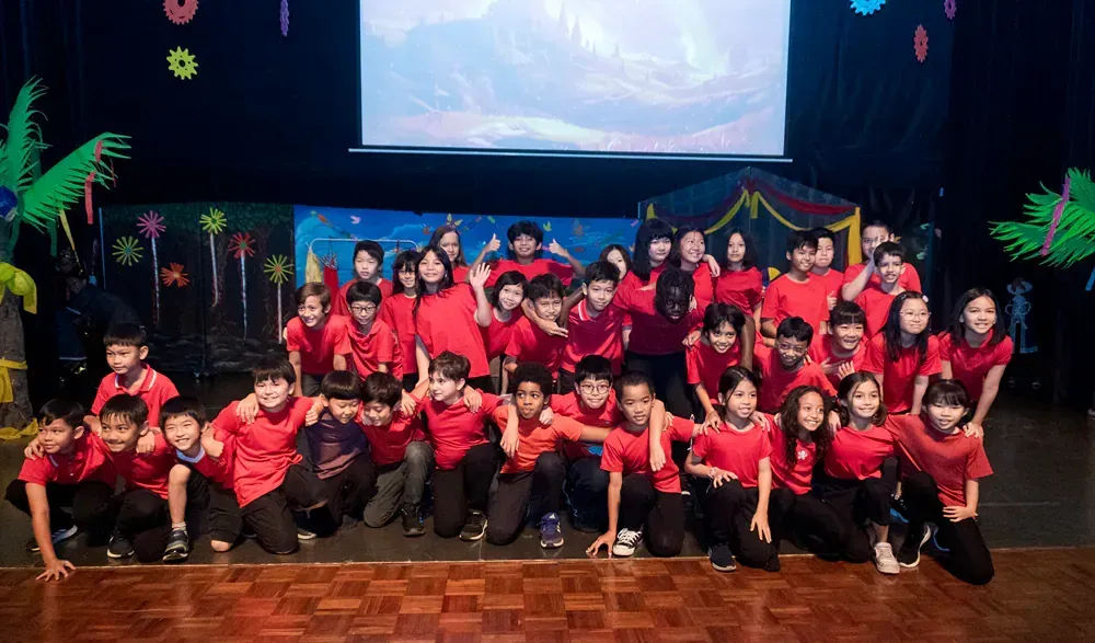 A group of children are posing for a picture on a stage.