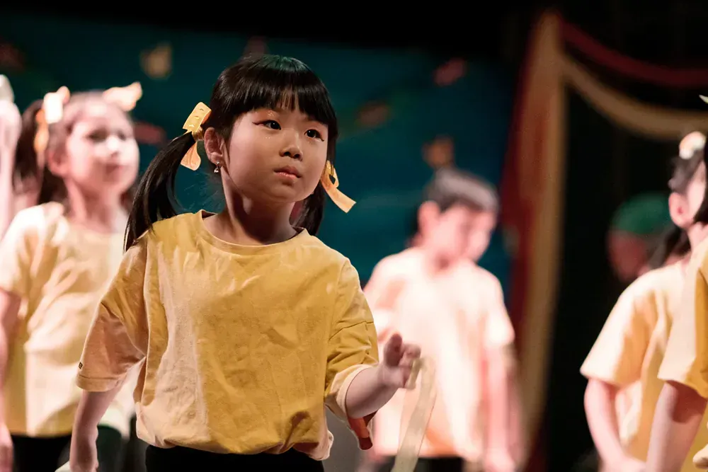 A group of young girls are dancing on a stage.