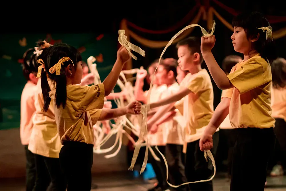 A group of children are playing with ropes on a stage.