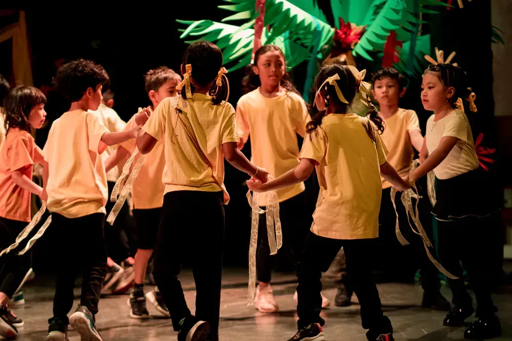 A group of children are dancing on a stage.