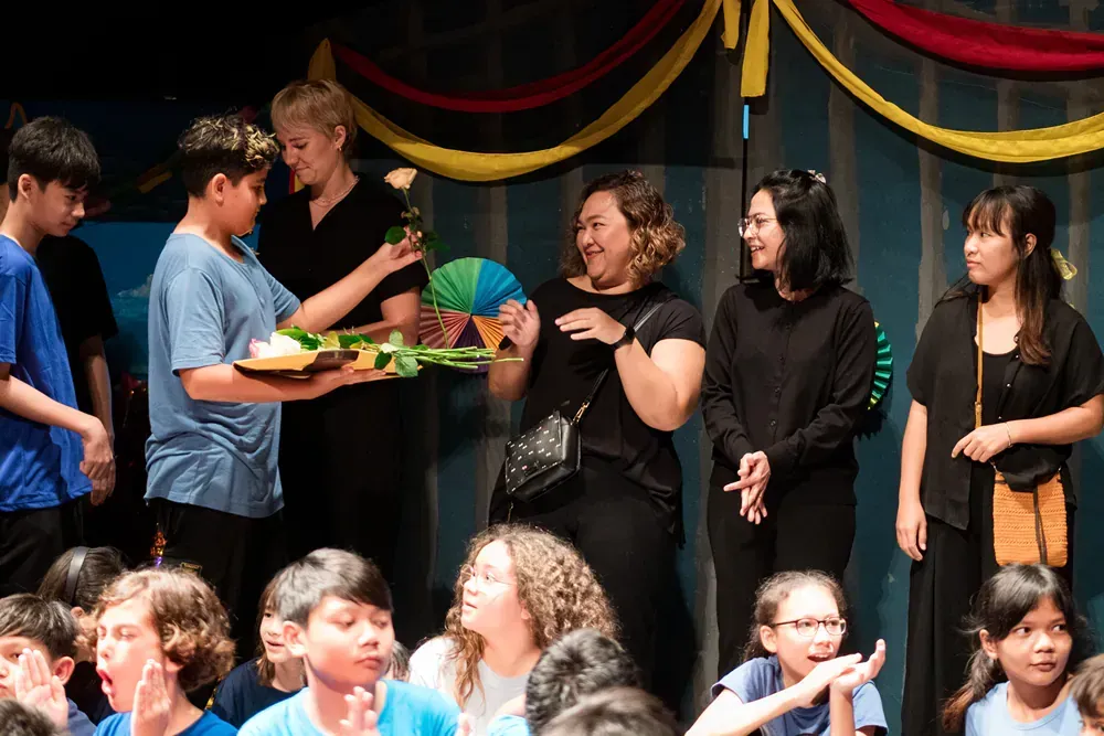 A group of people are standing on a stage in front of a crowd.