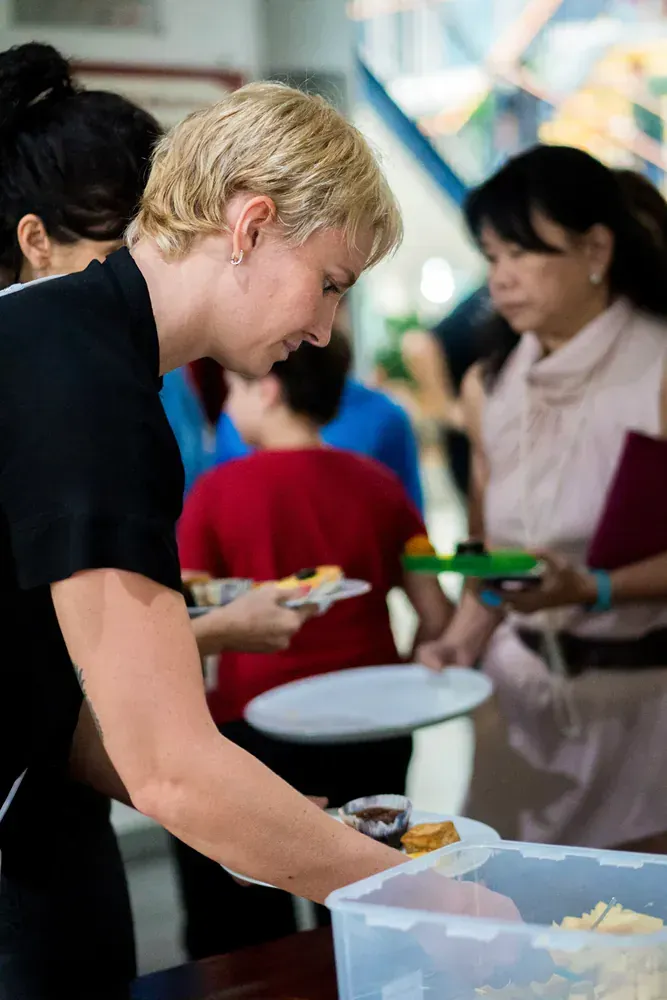 A woman is serving food to a group of people