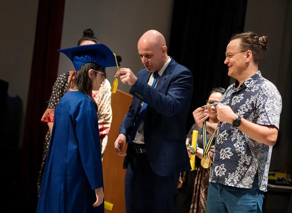 A group of people are standing around a woman in a graduation cap and gown.