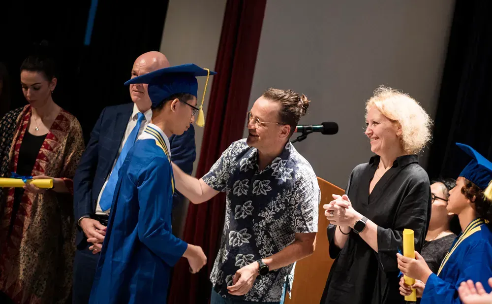 A group of people are standing around a man in a graduation cap and gown.
