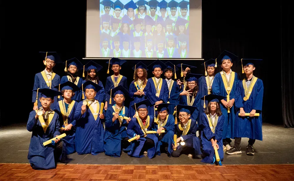 A group of graduates are posing for a picture on a stage.