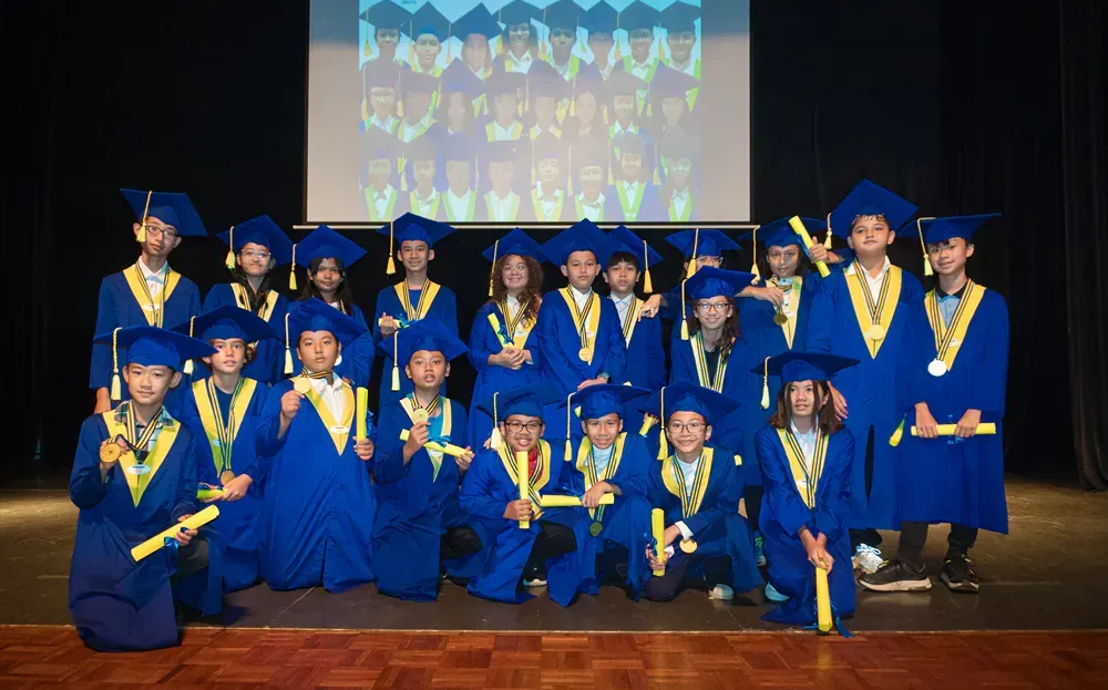 A group of graduates are posing for a picture on a stage.