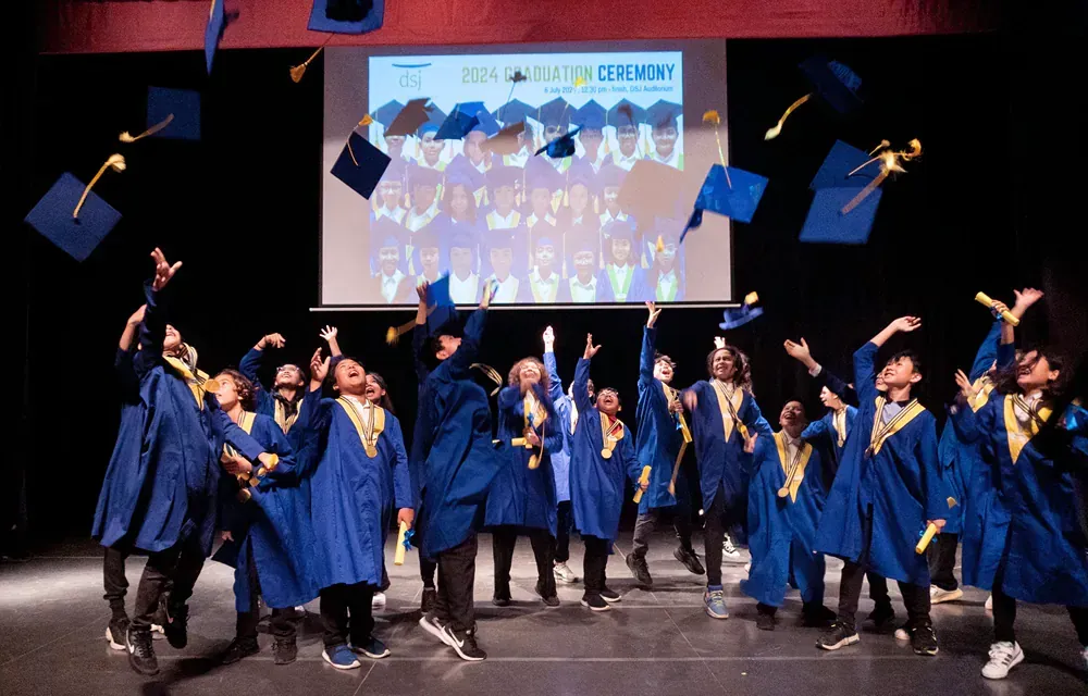 A group of graduates are throwing their caps in the air.