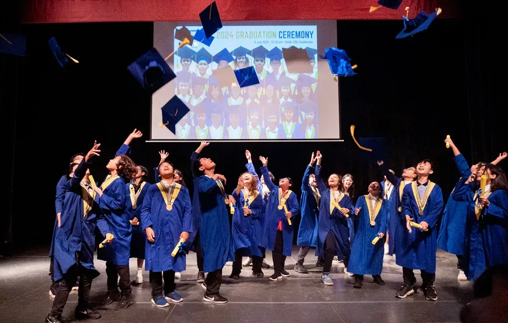 A group of graduates are throwing their caps in the air.