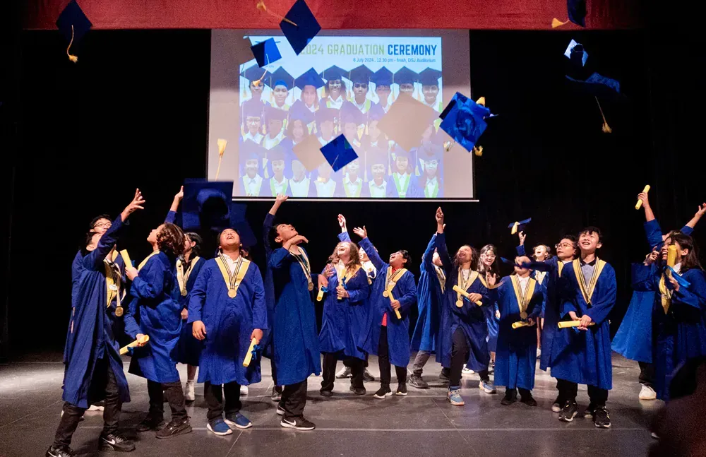 A group of graduates are throwing their caps in the air.
