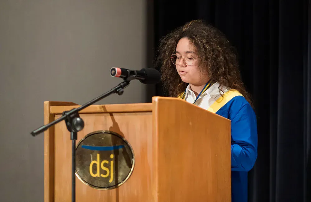 A woman is standing at a podium giving a speech.