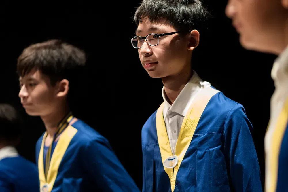 A group of young men are standing next to each other in a dark room.