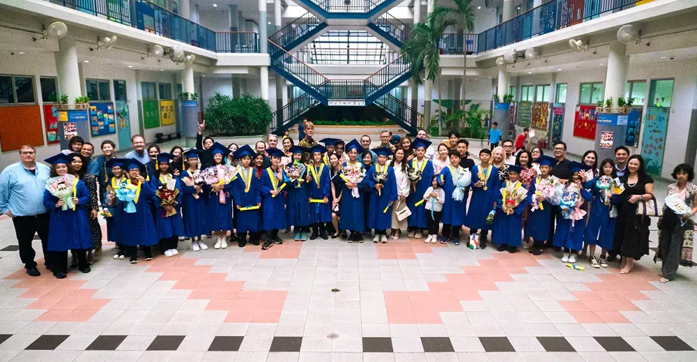 A large group of people in graduation gowns are posing for a picture