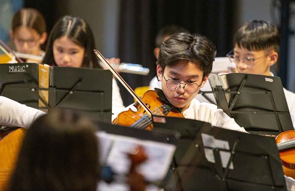 Curly hair student holding books in front of university