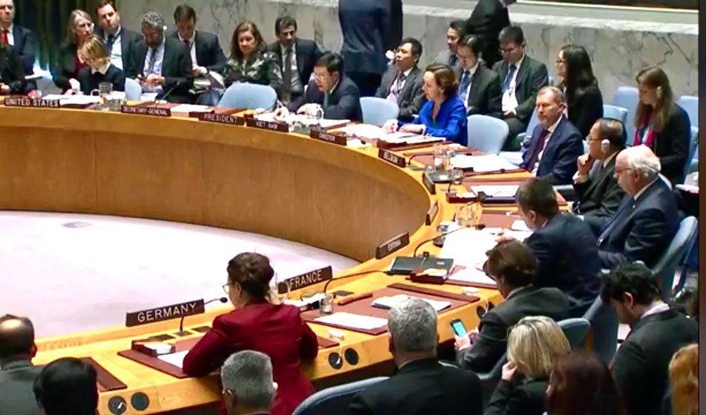 A group of people are sitting around a table with a sign that says ' russia ' on it