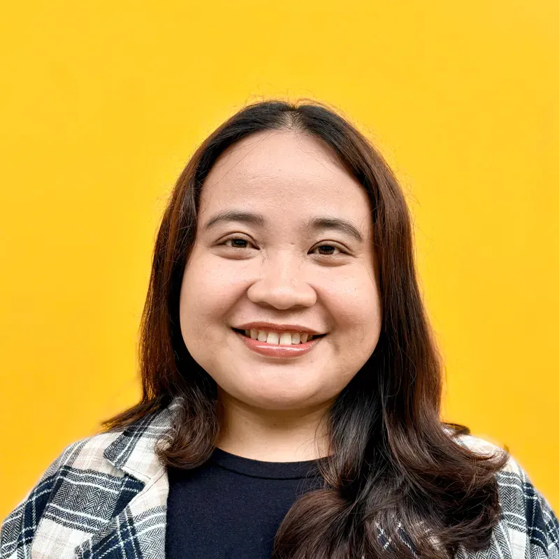 A woman with long dark hair and red lipstick is smiling for the camera.