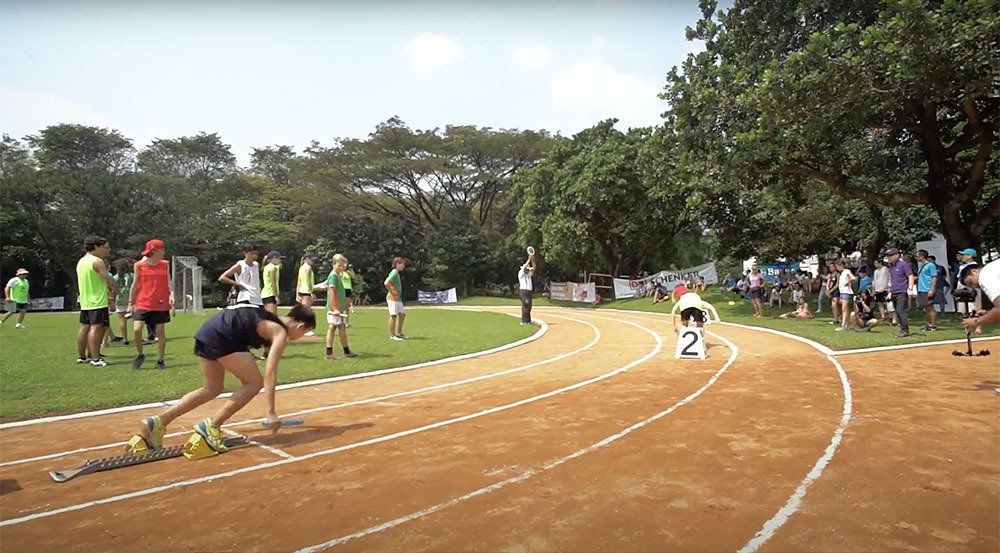 A group of people are running on a track in a park.