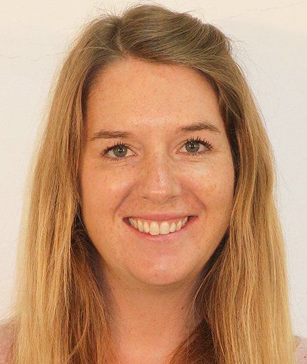 A woman with long blonde hair is smiling for the camera.