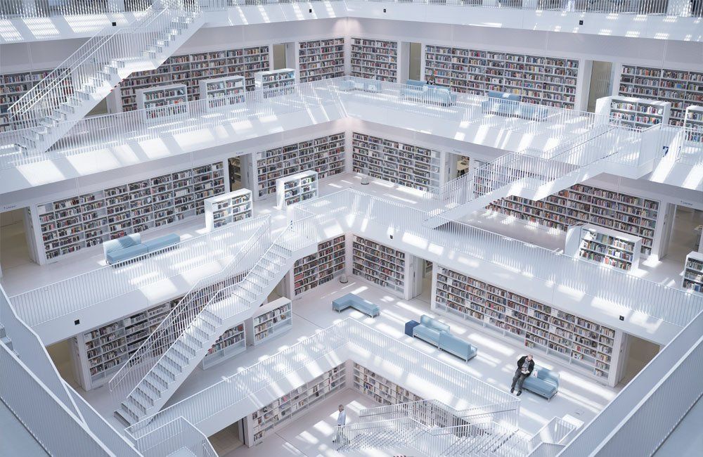 An aerial view of a library with a lot of bookshelves and stairs.