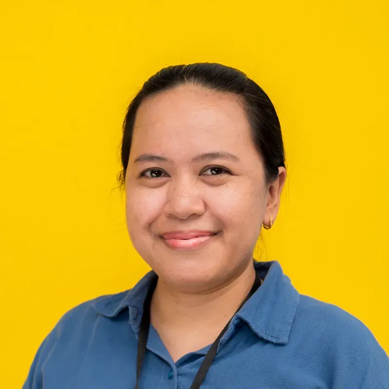 A woman in a plaid shirt is smiling for the camera.