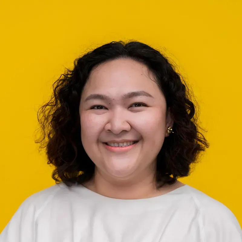 A woman in a blue striped shirt is smiling for the camera.