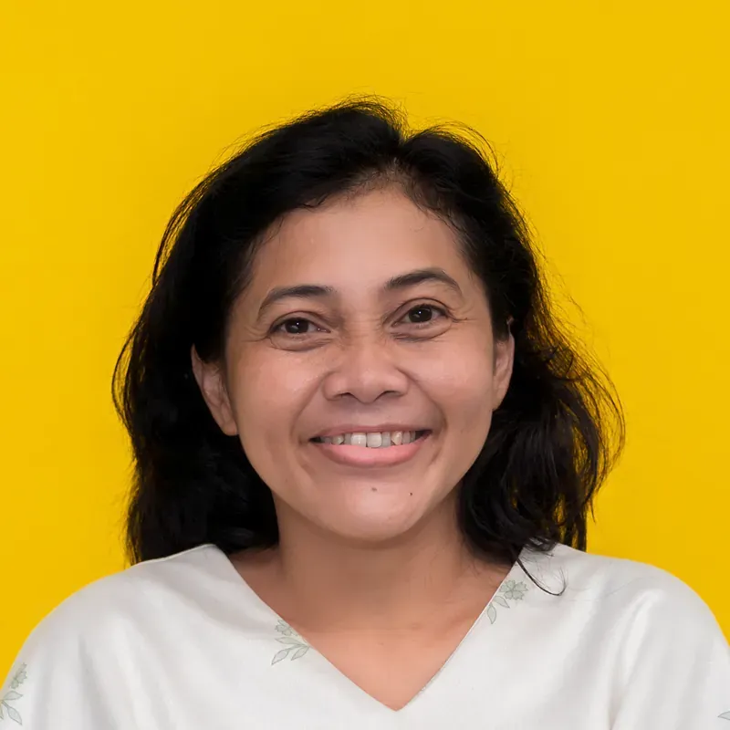 A woman in a green shirt is smiling for the camera.
