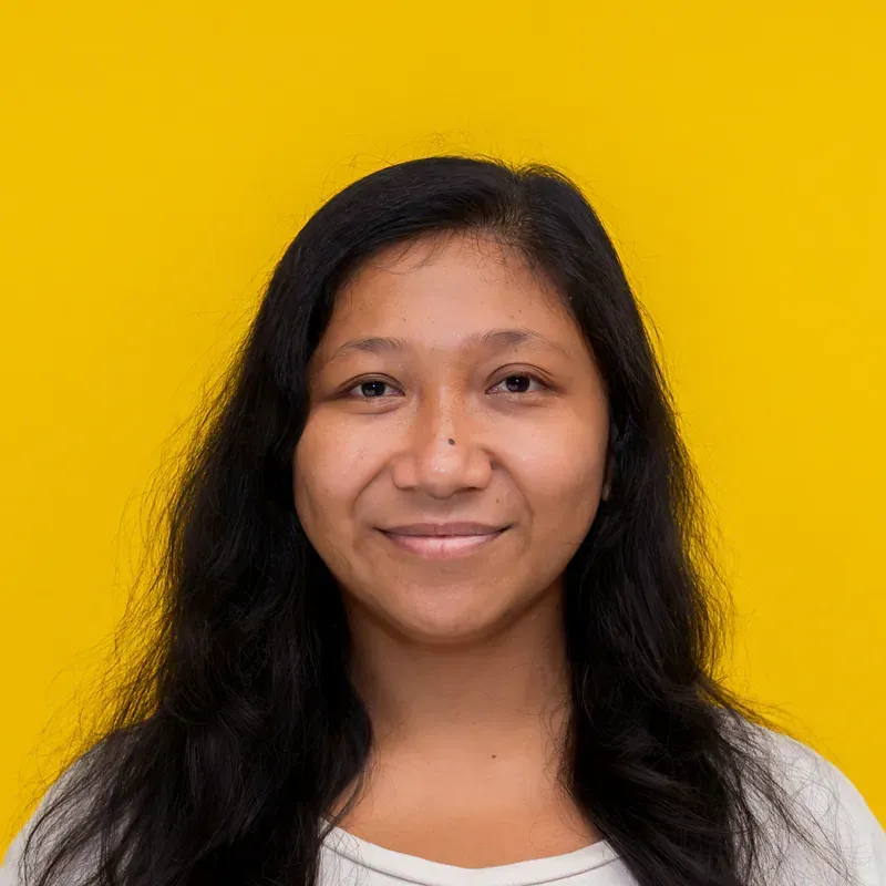 A woman with long dark hair is smiling for the camera.