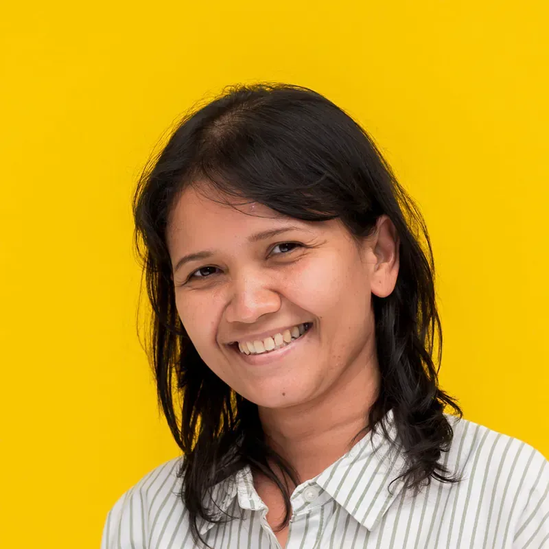 A woman with long dark hair is smiling for the camera