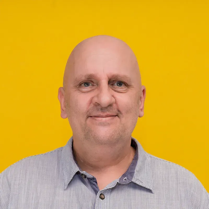A man with a bald head is smiling for the camera.