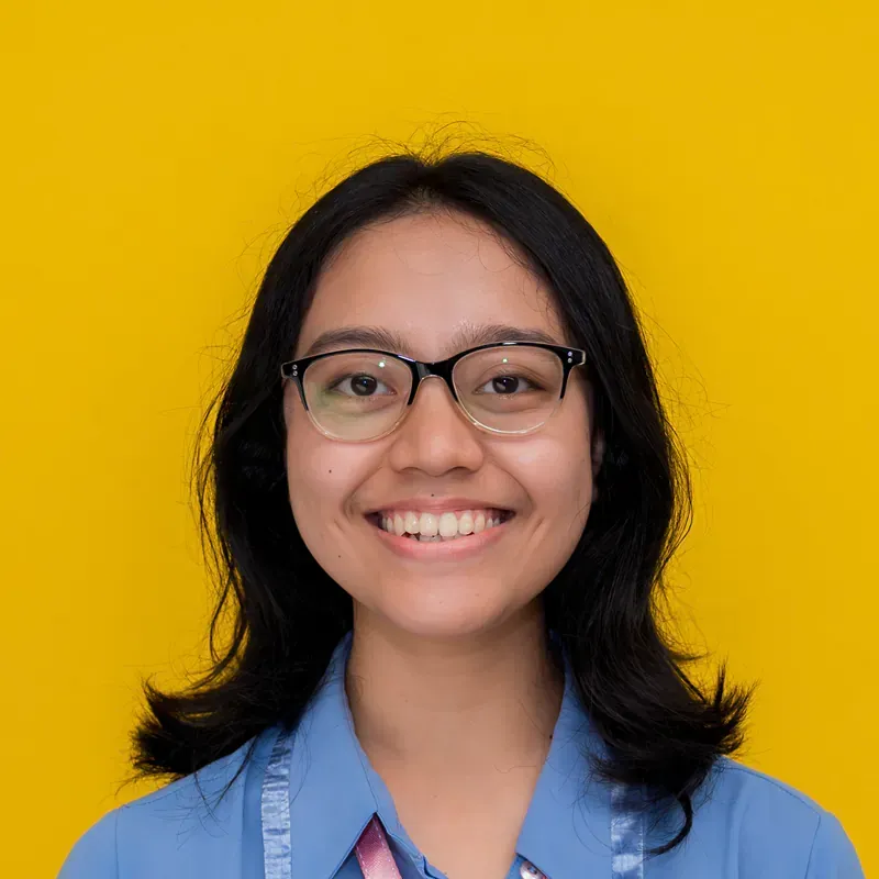 A woman with long hair is smiling and wearing a black shirt.