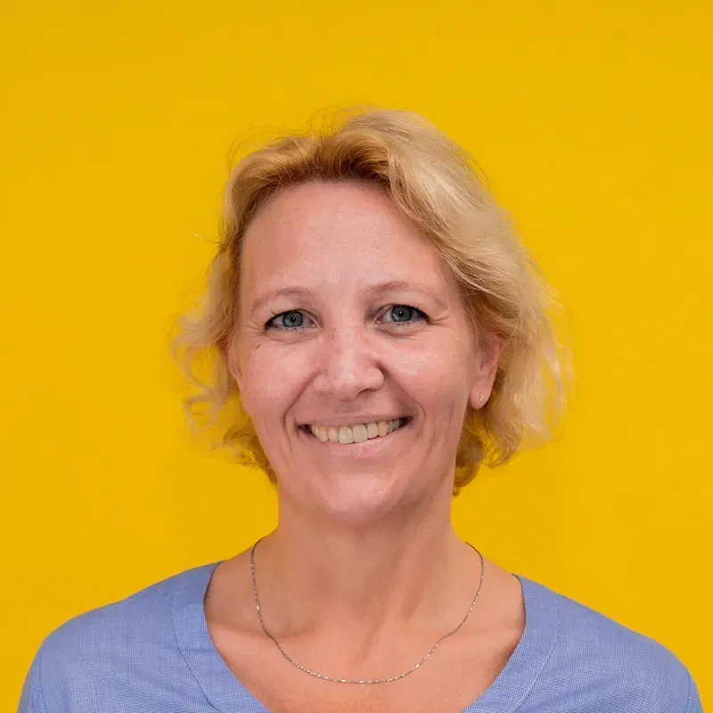 A woman is sitting at a table with a laptop computer.